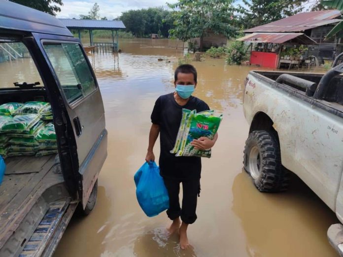 AGIHKAN..Pengerusi JPKK di salah kampung mengaih-agihkan bantuan makanan kepada salah seorang penduduk yang terjejas banjir di DUN Lamag.
