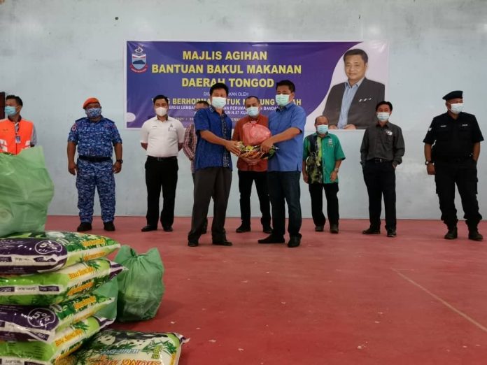 Masiung (4th right) presenting the food basket assistance to a JPKK Chairman as witnessed by the District Officer Mohd. Fauzi (centre).
