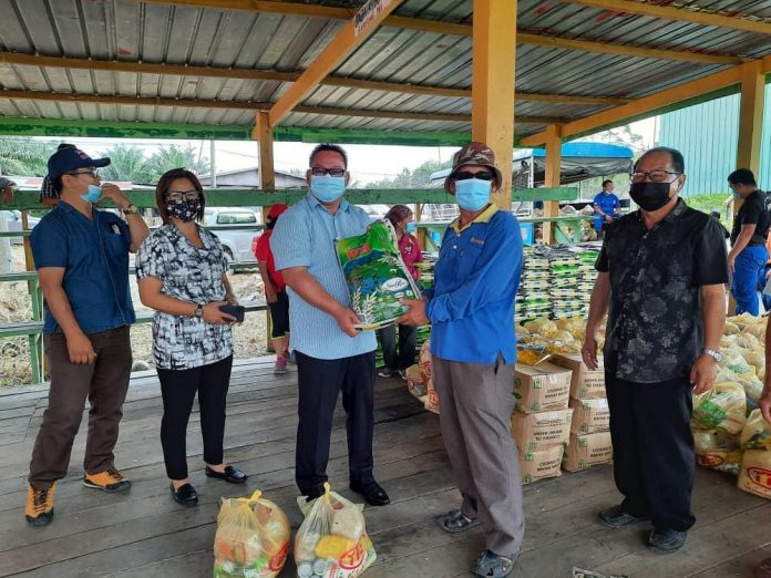 Adun Tandek Hendrus Anding (tiga, kiri) menyampaikan bantuan bakul makanan di Astaka Padang Kampung Goshen, semalam.