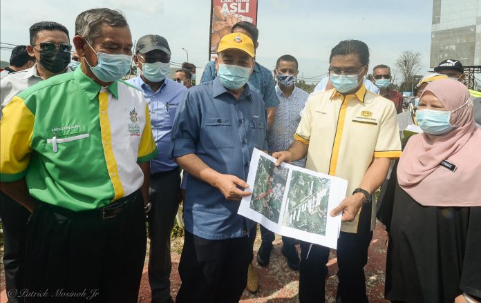 Chief Minister Datuk Seri Hajiji Haji Noor with PWD Director Ali Ahmad showing the road that will be upgraded during the working visit to the Kota Belud Roundabout on Monday.