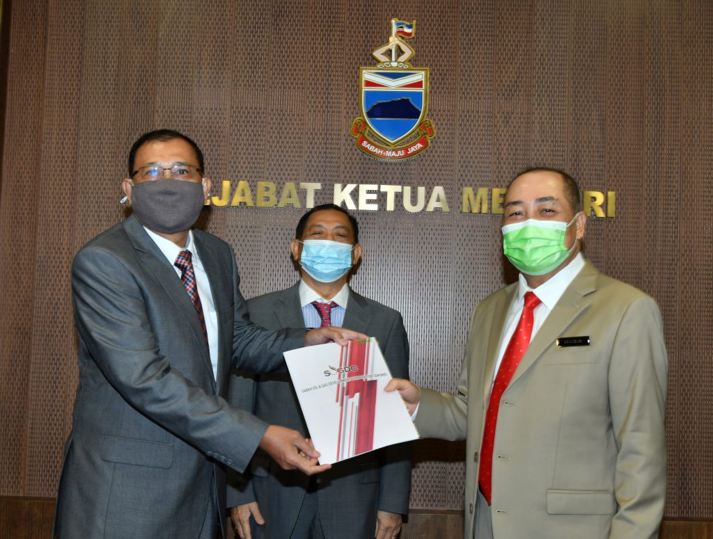 Chief Minister Datuk Seri Hajiji Haji Noor presenting the letter of appointment to former Petronas Chemicals Group Sabah Project Directorate Datuk Haji Mohd Shariff Haji Ibrahim (left) while Abdul Kadir (centre) looks on.