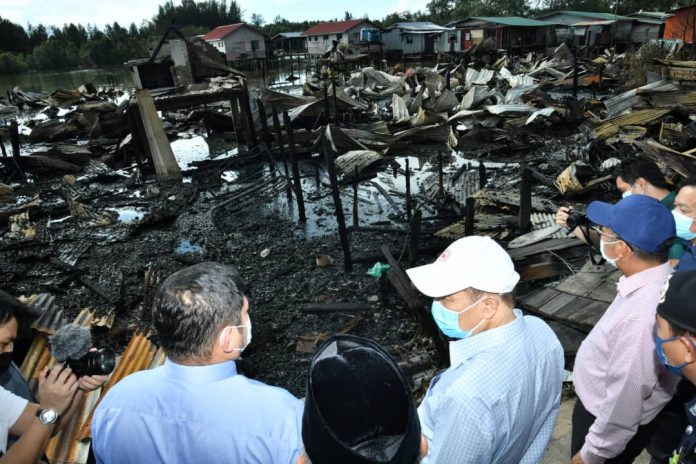 What's left of the 35 houses at Kampung Meruntum...Hajiji inspecting the site.
