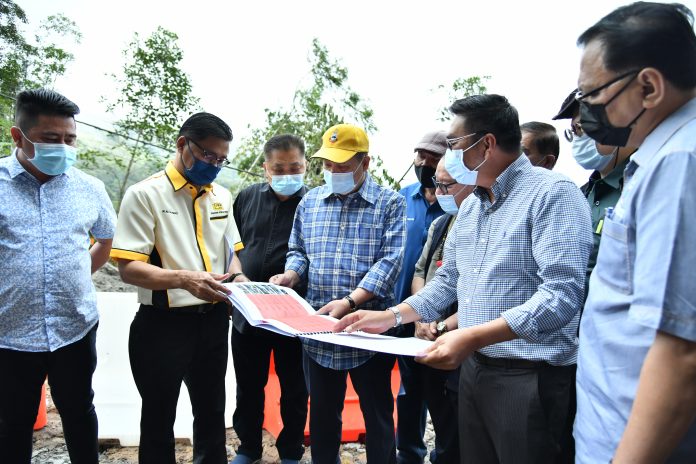 Chief Minister Datuk Seri Hajiji Noor being briefed on the damaged roads during the recent bad weather by PWD Director Ali Ahmad (second left)