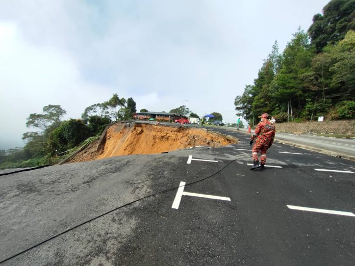 A member of the Fire and Rescue Department inspecting the scale of the damage caused by the landslide.