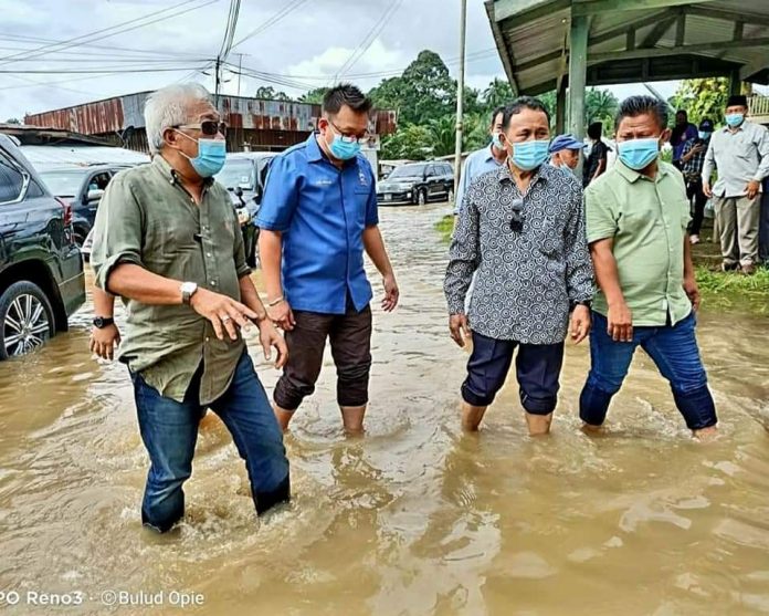 MEREDAH BANJIR…Bung diringi oleh PPM Lamag Abu Bakar meredah banjir semasa menemui penduduk yang terjejas banjir di kampung Pengkalan Bukit Garam