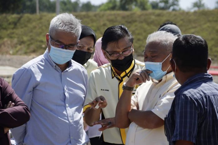 CaptionA.LAWAT..Bung diberikan penjelasan oleh Pengarah JKR Ali Ahmad Hamid dan Pengarah Air Edward Lingkapo ketika meninjau kemajuan pembinaan jejambat (flyover ) di Rampayan Mengatal B.PERHATI..Bung diberikan penjelasa