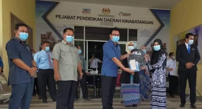 Pemimpin Pembangunan Masyarakat (PPM) Lamag Abu Bakar Gapar yang mewakili Bung menyampaikan sumbangan kepada salah seorang guru sempana majlis tersebut.