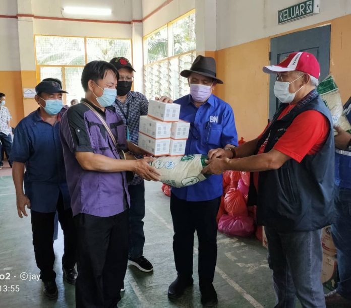 SERAH..Bung bersama Mohd Jasmin dan Juhari menyerahkan bantuan bakul makanan dan alat pelitup muka kepada wakil penduduk di kampung Keramuak.