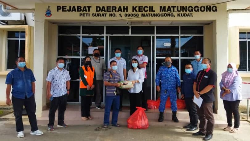 Julita menyerahkan bantuan bakul makanan kepada salah seorang  Ketua Isi Rumah bagi kawasan Matunggong di Pejabat Daerah Kecil Matunggong kelmarin.