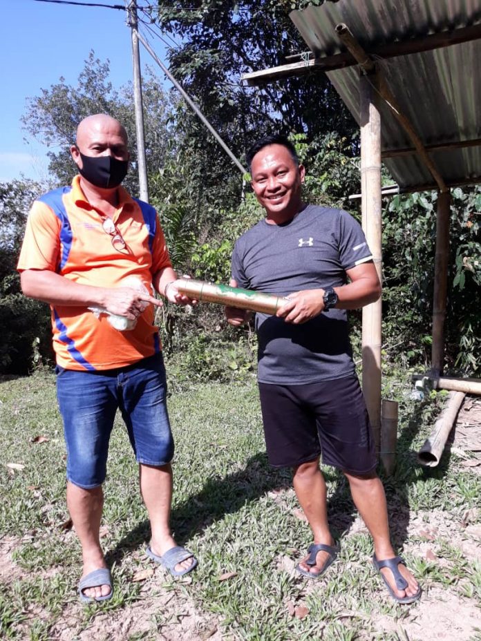 BOE Menyerahkan set bulu tangkis kepada wakil belia Kampung Linsuk, Henry Ujin.