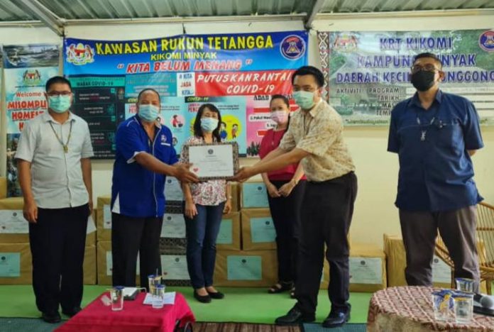 Julita (tengah) memerhatikan gimik serahan PPE kepada wakil JKNS Kudat, Doktor Daniel Sunggin (dua, Kanan).