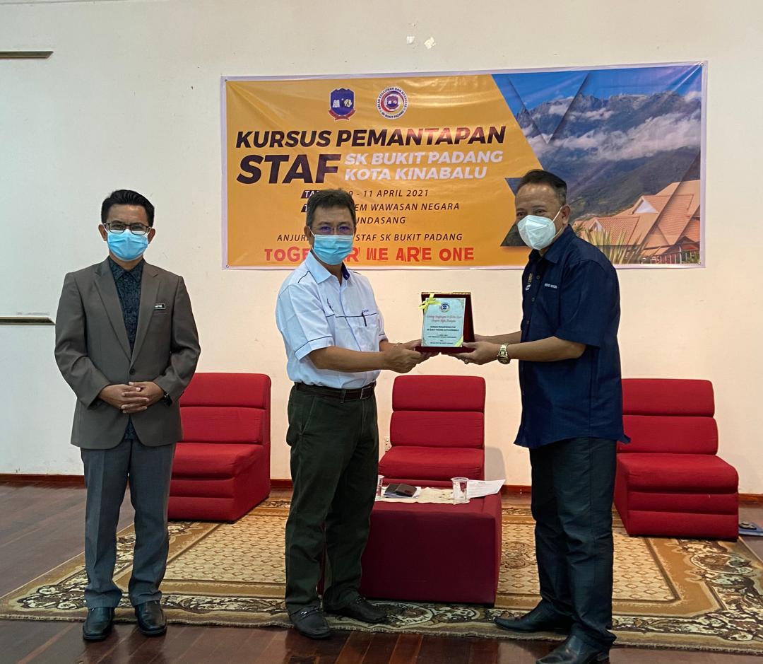 Dr. Joachim Gunsalam (dua, kiri) menerima cendera kenangan daripada Guru Besar SK Bukit Padang, Kota Kinabalu dalam Majlis Perasmian Penutupan kursus Perkembangan Warga Pendidik SK Bukit Padang, Kota Kinabalu, di Dewan Kem Wawasan Negara, Ranau.