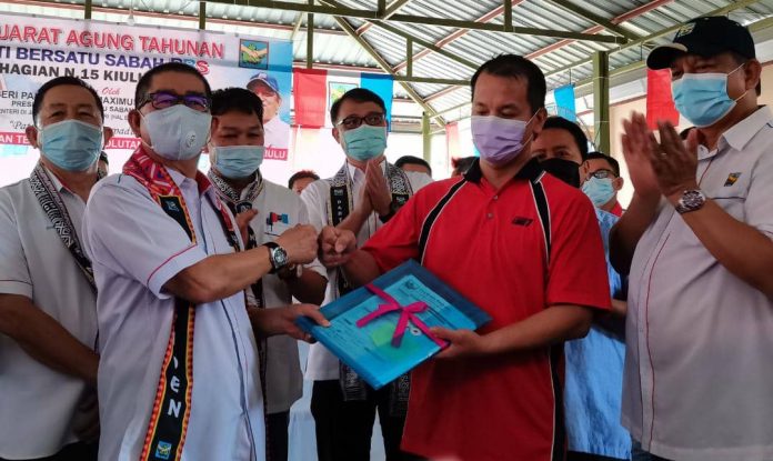 PBS President Datuk Seri Dr Maximus Ongkili receiving new membership forms after the N15 Kiulu PBS Annual General Meeting launch, today, while PBS Secretary-General cum Kiulu Assemblyman Datuk Joniston Bangkuai and others look on.