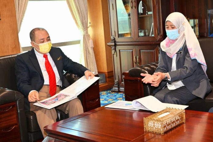 Anita memberi taklimat kepada Hajiji semasa kunjungan hormat itu.