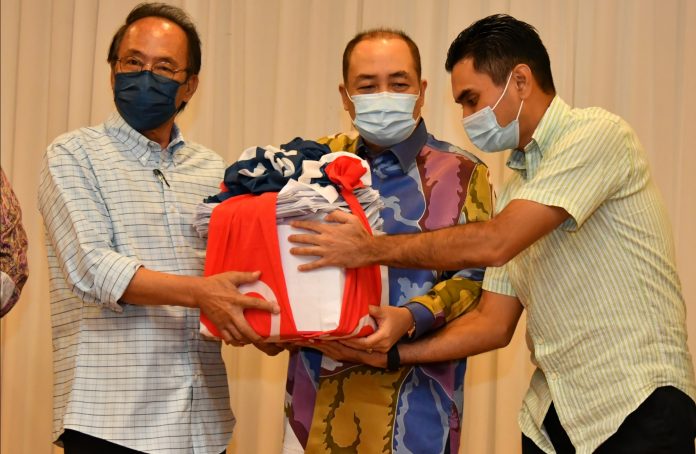 Chief Minister Datuk Seri Hajiji Haji Noor who is also Bersatu Sabah chief receiving 10,000 membership application forms from Bersatu Zone 5 Cheif Datuk Zakaria Edris (left) during the programme with the people in Sandakan on Thursday night.