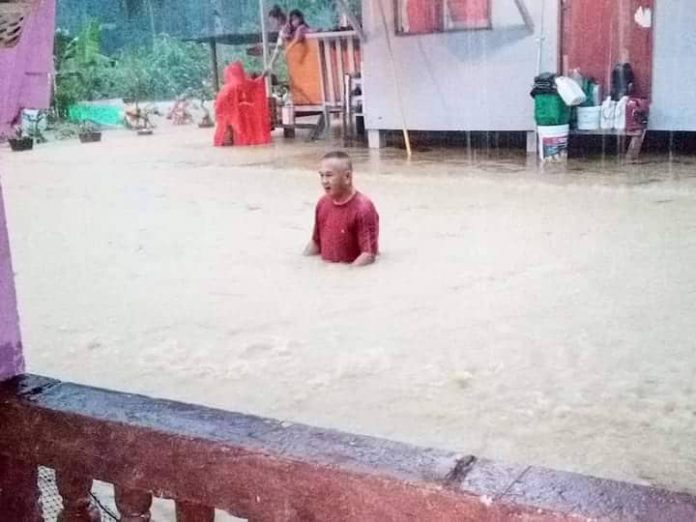 Gostim mengharungi banjir yang meneggalami rumahnya.