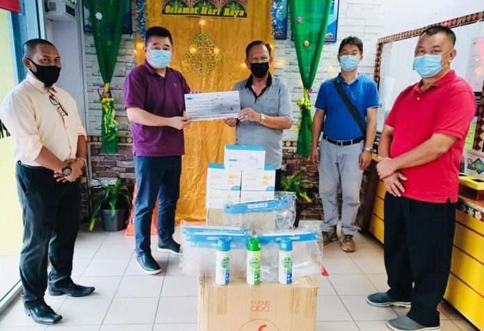 Chin (dua kiri) menerima replika cek dari Haji Sapena Tolak sambil diperhatikan oleh yang lain di pejabat LPKP cawangan Sandakan