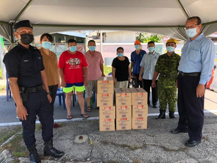 Lu (far right) after handing over the mineral water at one of the roadblocks