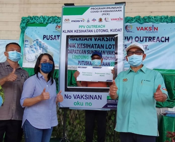 Minister in the Prime Minister's Department (Sabah and Sarawak Affairs) Datuk Seri Dr Maximus Ongkili posed for the camera with 87-year-old Tuawam Buanin who had his first dose of the Covid-19 vaccine at the Lotong Health Clinic in Matunggong, while Matunggong Assemblywoman Datuk Julita Majungki looks on.