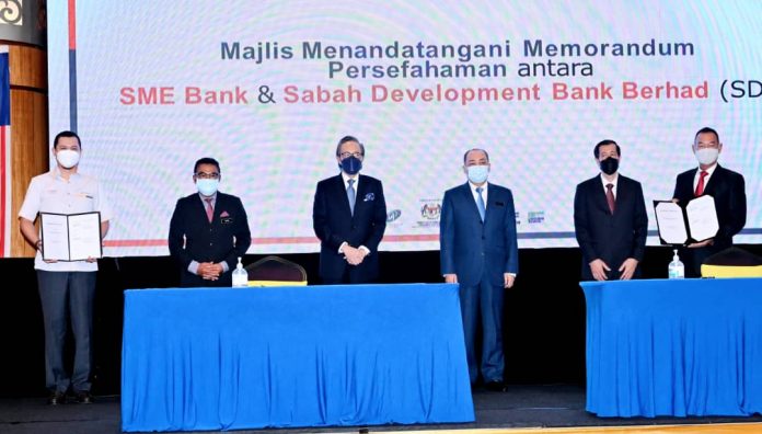 Hajiji (empat dari kiri) bersama Masidi, Aria (kanan) dan Vincent Pung (kanan) selepas majlis menandatangani MOU diantara SME Bank dan Sabah Development Bank.
